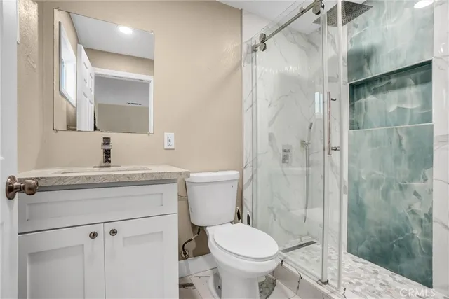 a bathroom with a sink a toilet and shower