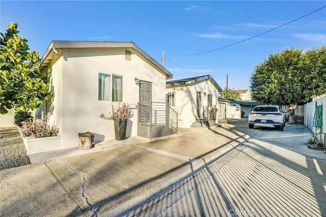 a view of a house with car parked on the road