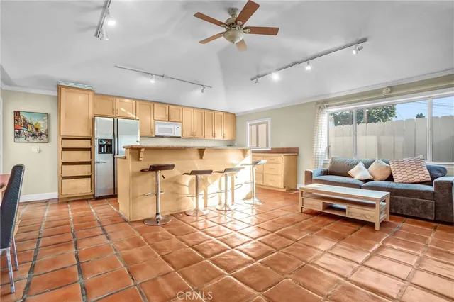 a living room with stainless steel appliances kitchen island granite countertop a rug and a view of kitchen