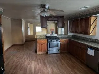 a kitchen with stainless steel appliances granite countertop a stove a sink dishwasher and a microwave oven with cabinets
