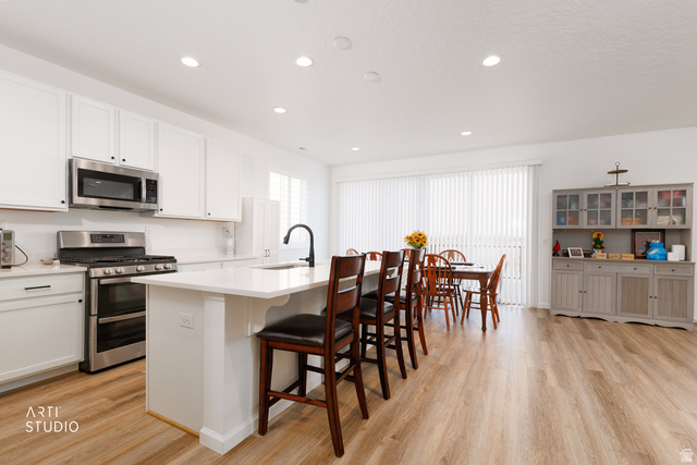 540 Lefty Lane Tooele, UT 84074 - Photo 6 of 48 Kitchen with a breakfast bar, stainless steel appliances, a center island with sink, light wood-type flooring, and recessed lighting