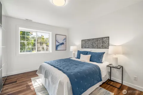 a bedroom with a bed and wooden floor