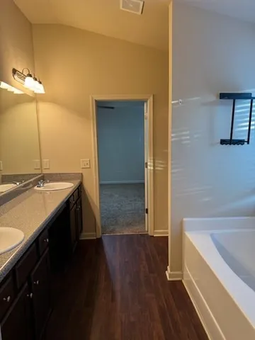 a spacious bathroom with a granite countertop sink a toilet and bathtub
