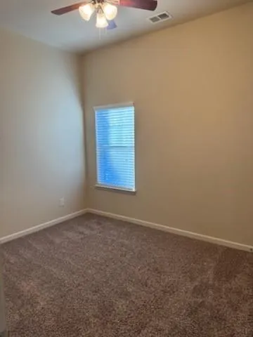an empty room with a chandelier fan