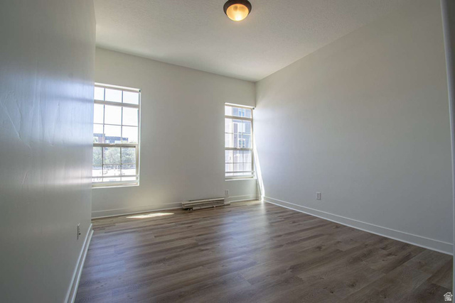 4276 South Main Street, Unit 303 Murray, UT 84107 - Photo 13 of 20 Spacious room featuring wood-finish flooring, white baseboards, and two multi-pane windows