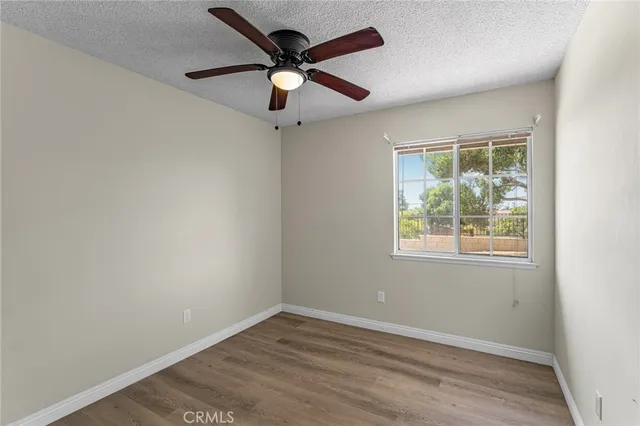 an empty room with a window and a fan