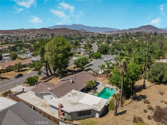 an aerial view of a house with a mountain
