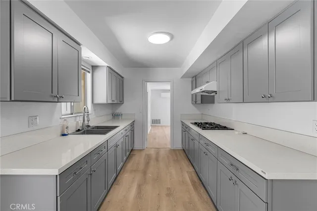 a kitchen with a sink stove and cabinets