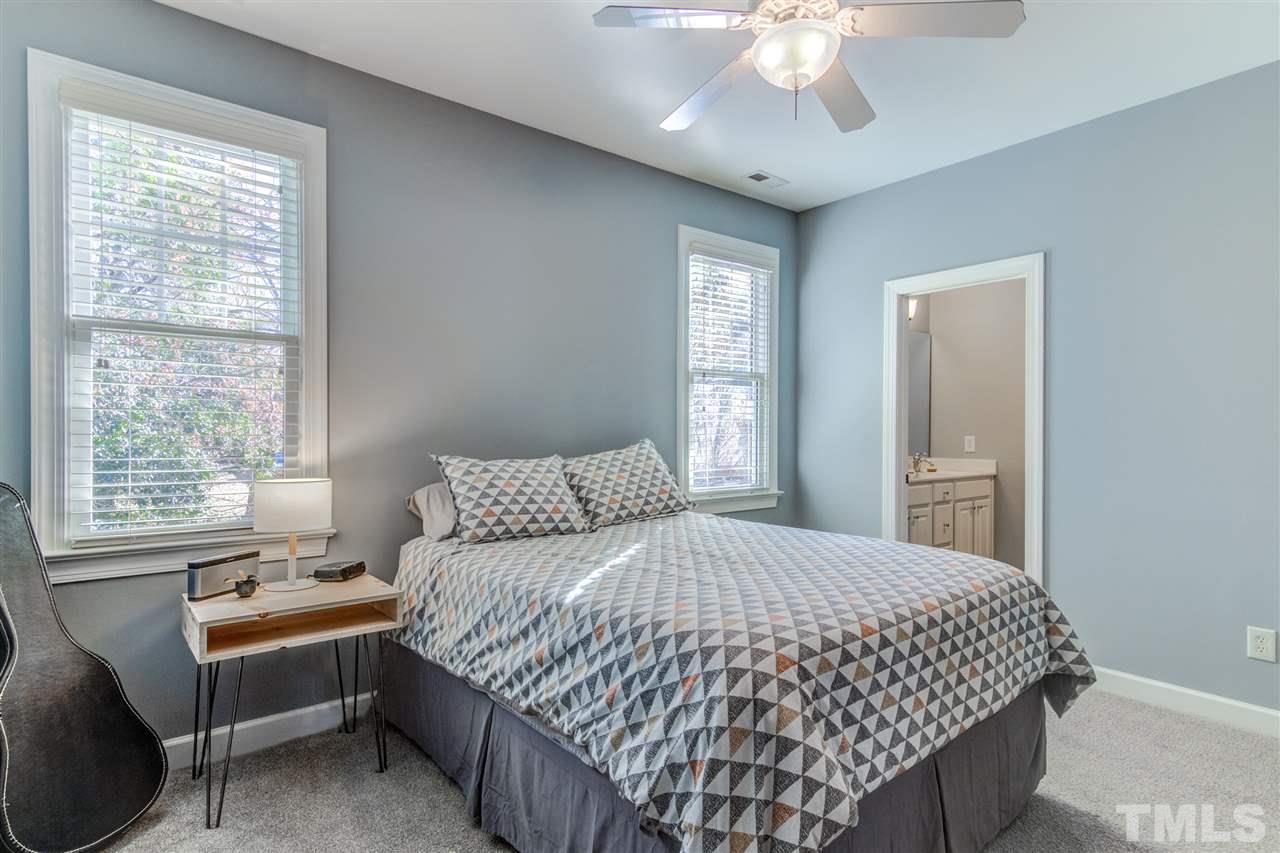 816 Cotton Exchange Court Raleigh, NC 27608 - Photo 12 of 25 a bedroom with a bed and a chandelier