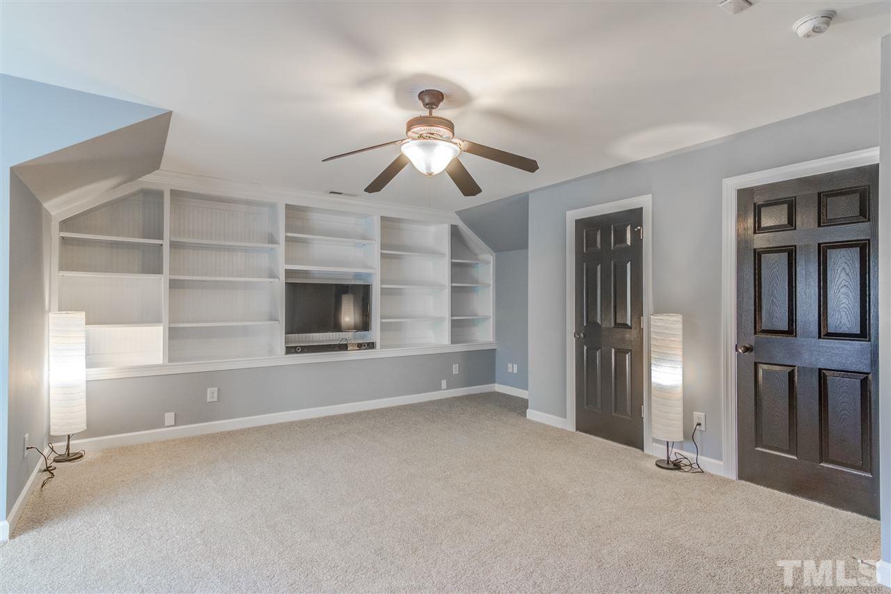 816 Cotton Exchange Court Raleigh, NC 27608 - Photo 20 of 25 a view of an empty room with a fireplace and a fan
