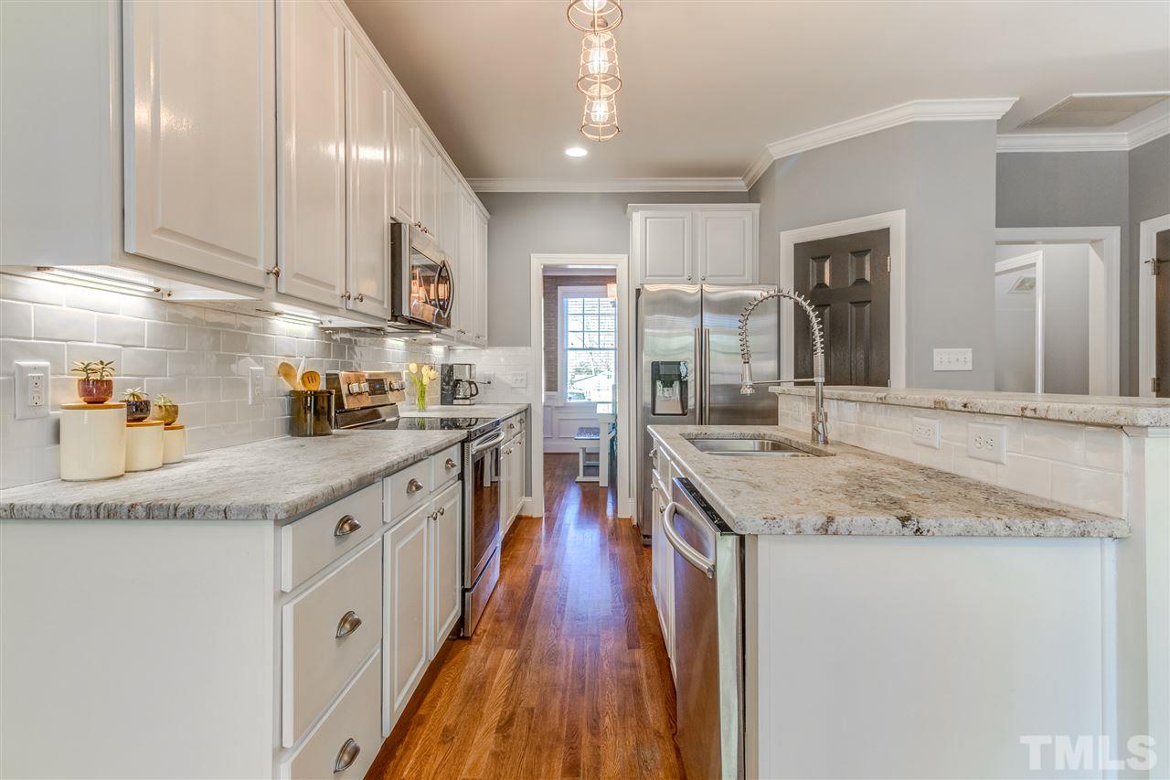 816 Cotton Exchange Court Raleigh, NC 27608 - Photo 6 of 25 a kitchen with lots of counter top space and wooden floor
