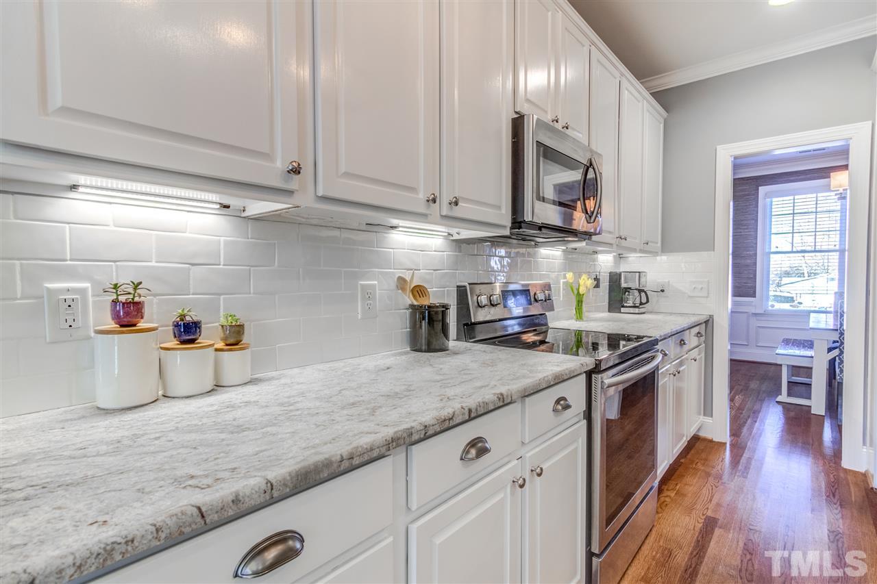 816 Cotton Exchange Court Raleigh, NC 27608 - Photo 7 of 25 a kitchen with stainless steel appliances granite countertop a sink a stove and cabinets