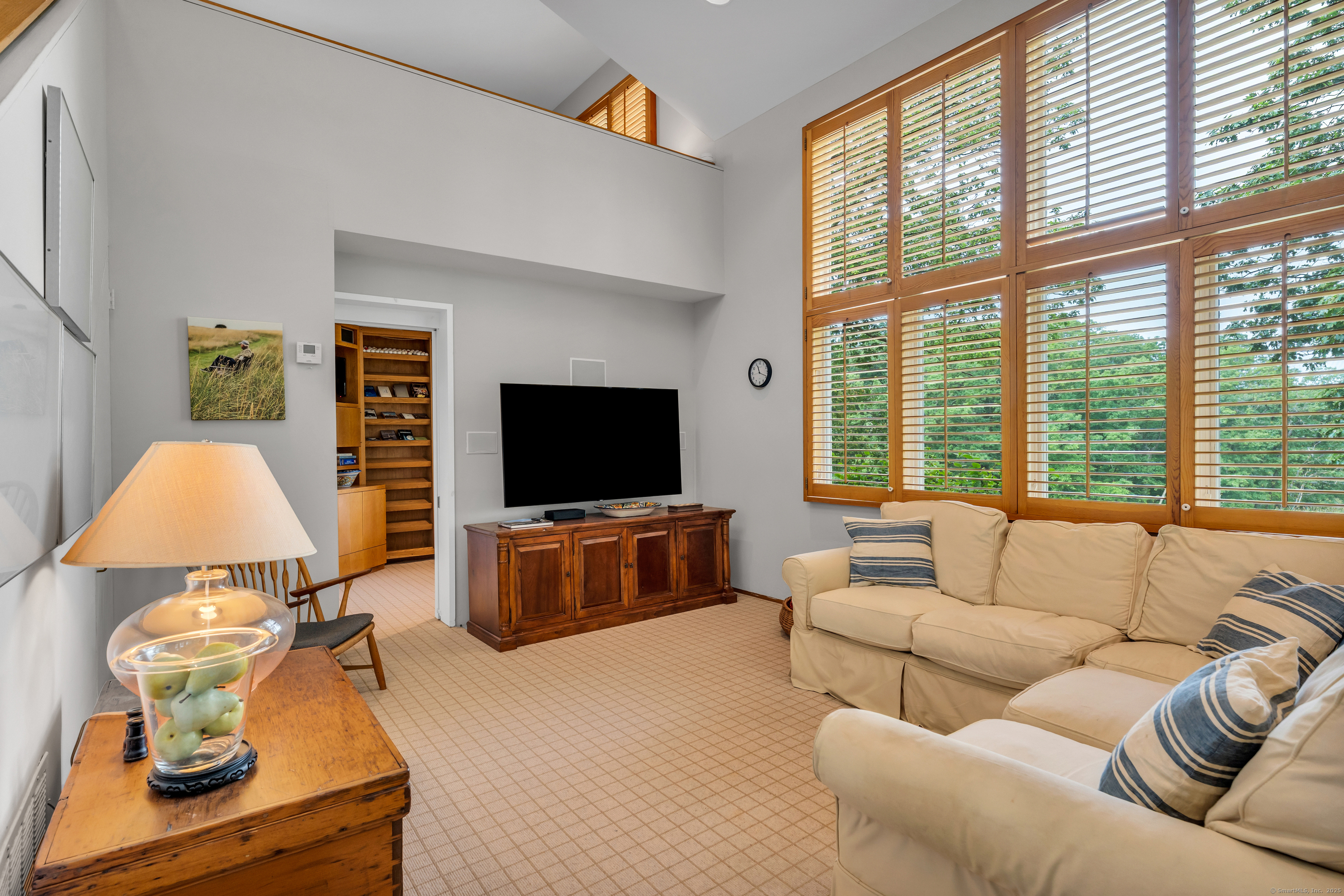 51 Andrews Road Guilford, CT 06437 - Photo 28 of 40 The 2 story Family Room. Above is a Loft Bedroom, past the door is a full bath and display case.