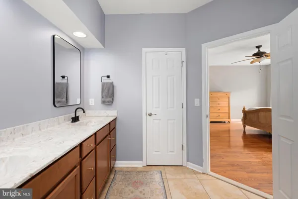 a spacious bathroom with double vanity sink a mirror and a toilet