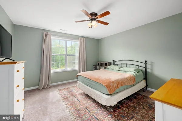 a bedroom with a large bed and a flat tv screen on dresser