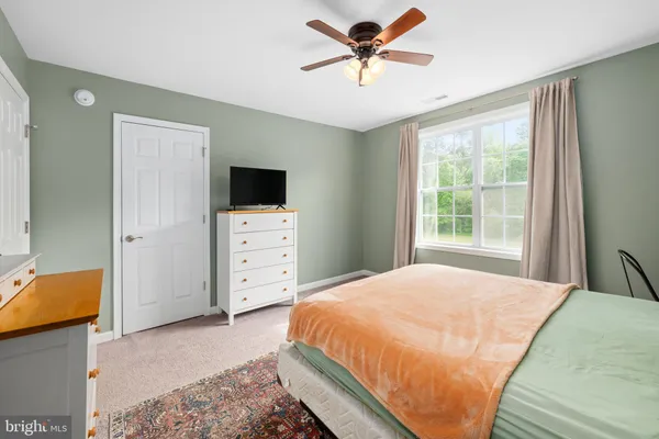 a bed sitting in a bedroom chandelier and dresser