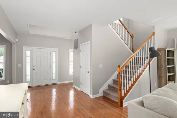 a view of a livingroom with wooden floor and stairs