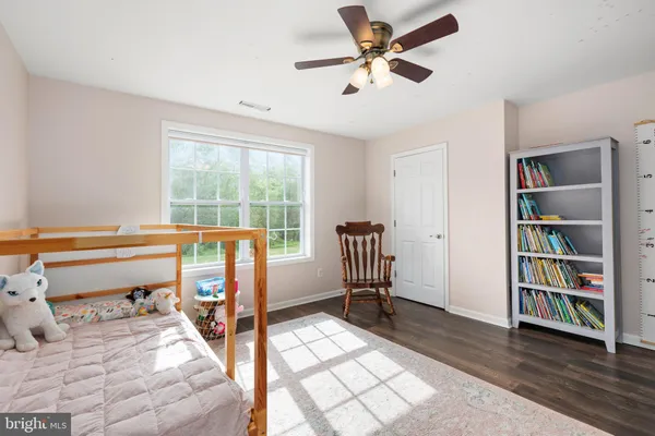 a view of a bedroom with furniture and book shelf