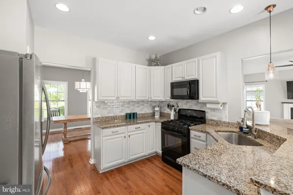 a kitchen with a sink stove top oven and refrigerator