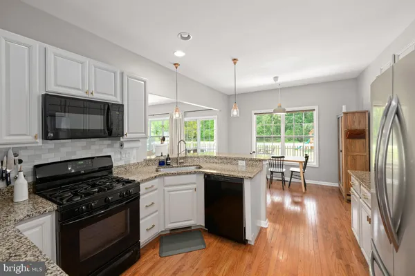 a kitchen with stainless steel appliances a stove a sink a microwave a refrigerator and cabinets