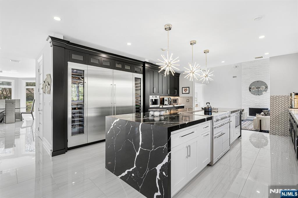 817 West Shore Drive Butler, NJ 07405 - Photo 13 of 50 a kitchen with stainless steel appliances kitchen island granite countertop a refrigerator a oven a sink and white cabinets with wooden floor