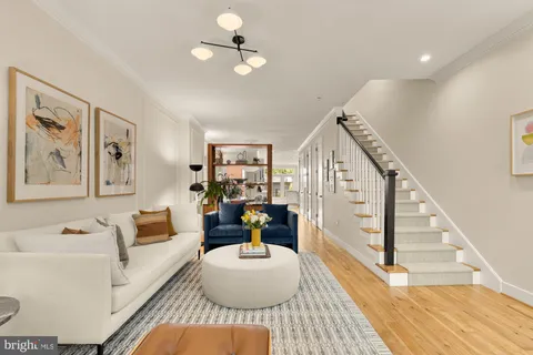 a living room with furniture and wooden floor