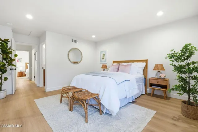 a bedroom with a bed and a potted plant