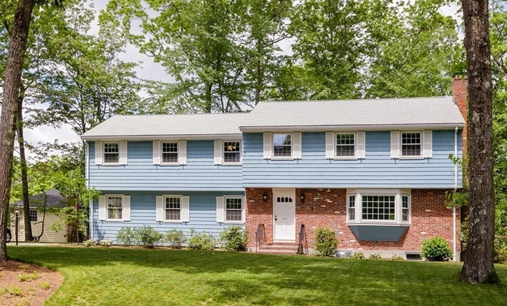a front view of a house with a yard and trees
