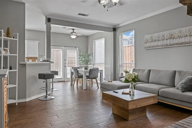a living room with furniture wooden floor and a large window