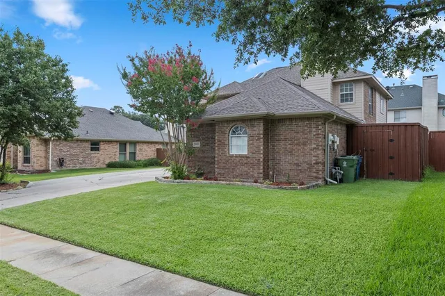 a front view of a house with a garden and trees