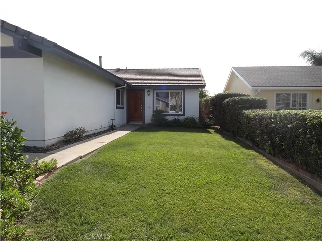 a view of a house with a yard and pathway