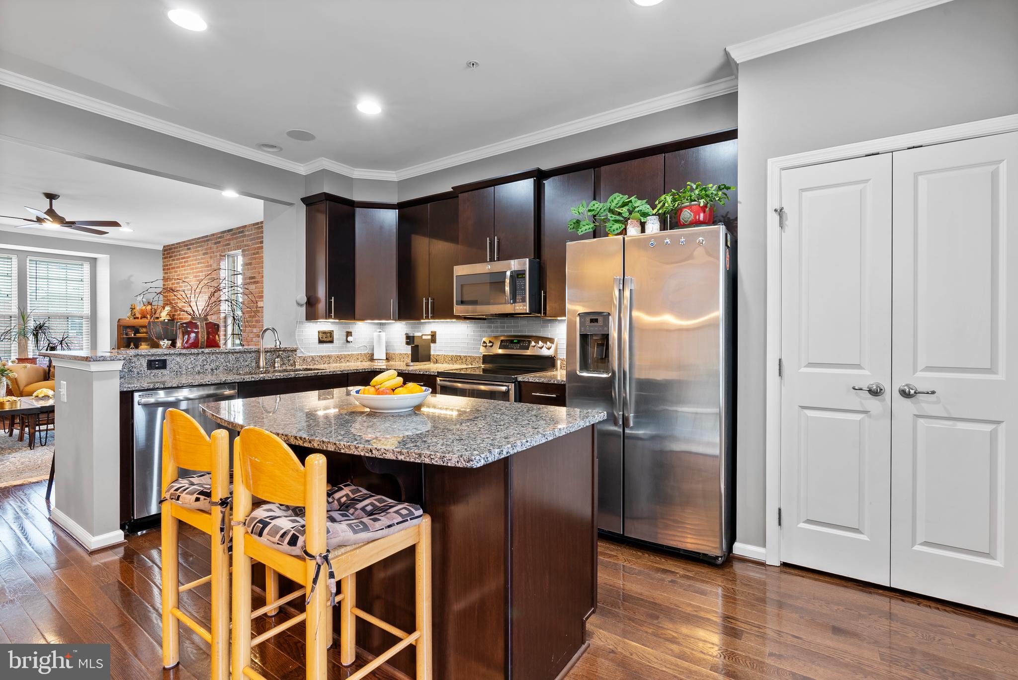 834 Oldham Street Baltimore, MD 21224 - Photo 12 of 55 a kitchen with stainless steel appliances granite countertop a refrigerator a stove and a wooden floors