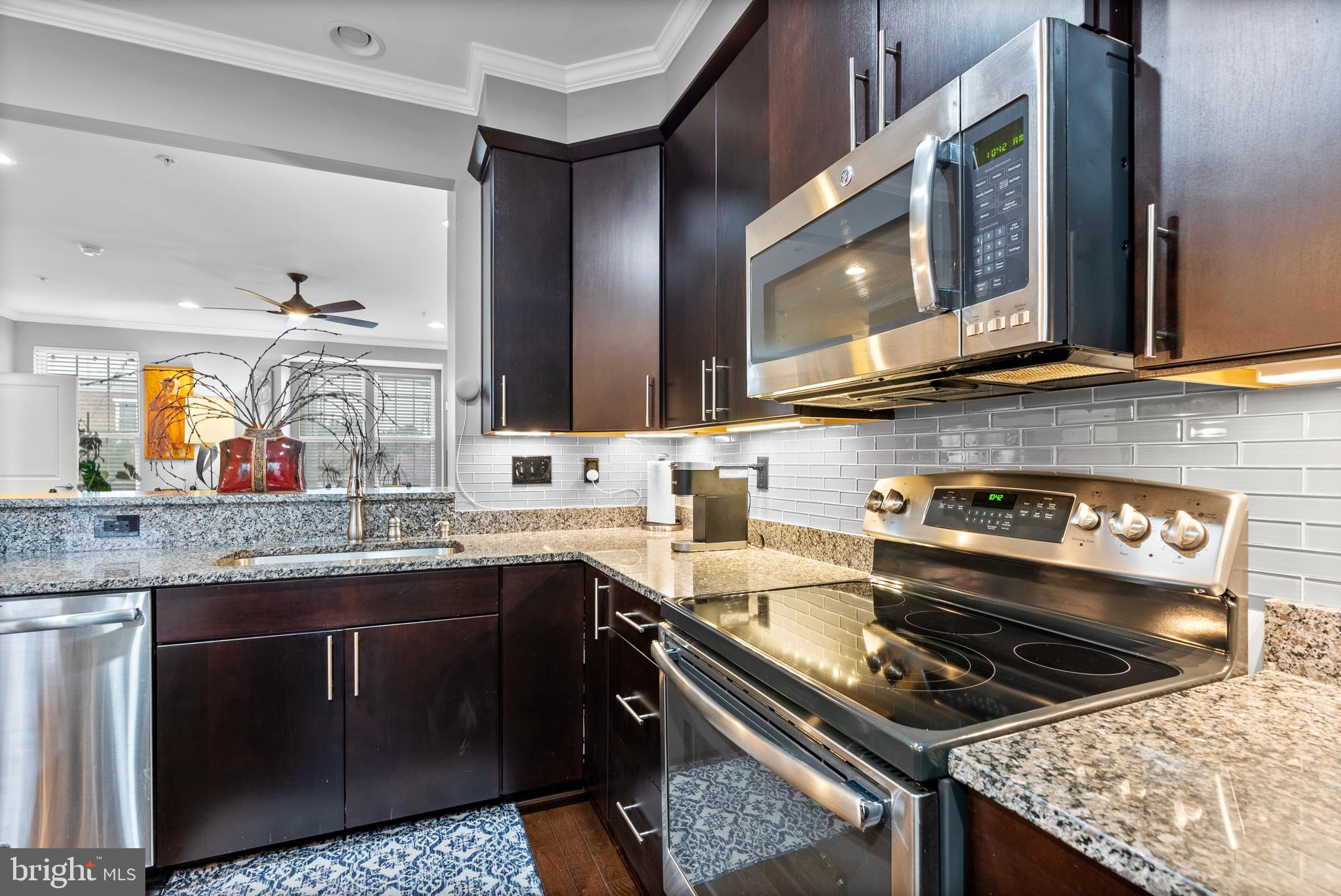 834 Oldham Street Baltimore, MD 21224 - Photo 15 of 55 a kitchen with stainless steel appliances granite countertop a stove a sink and a microwave