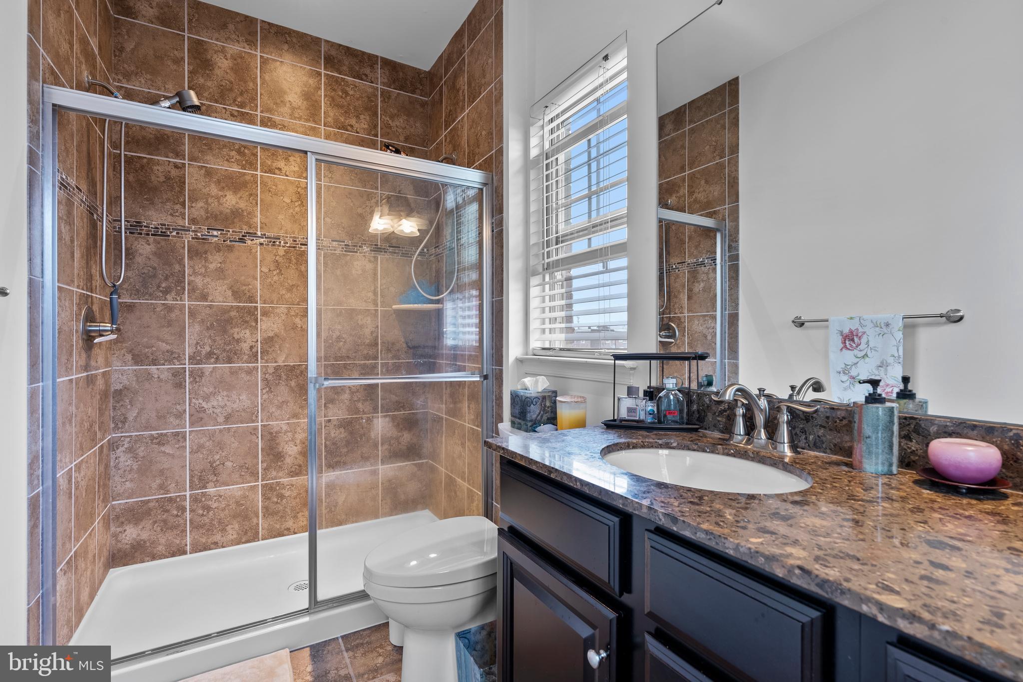 834 Oldham Street Baltimore, MD 21224 - Photo 34 of 55 a bathroom with a granite countertop sink a toilet a mirror and shower