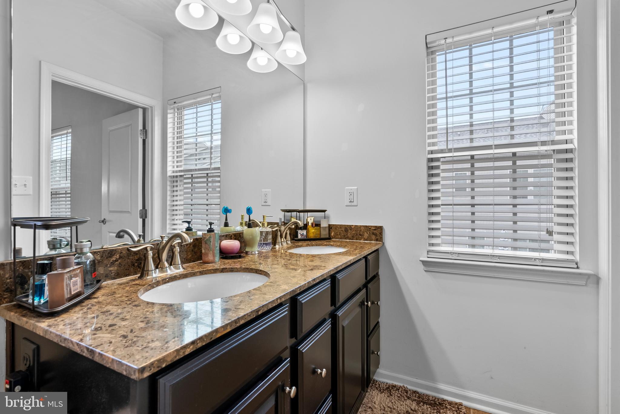 834 Oldham Street Baltimore, MD 21224 - Photo 36 of 55 a bathroom with a granite countertop sink a mirror and a window