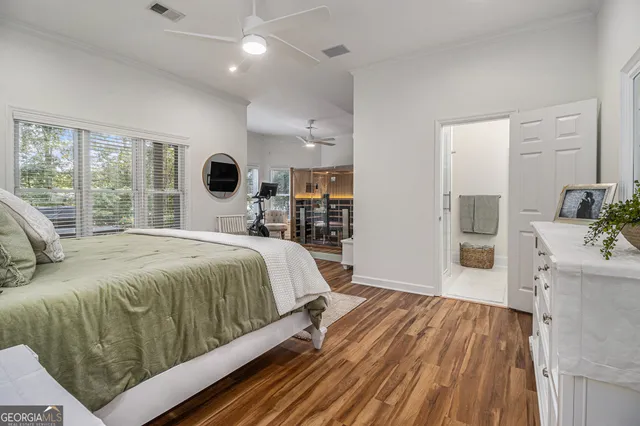 a bedroom with a large bed and a wooden floor
