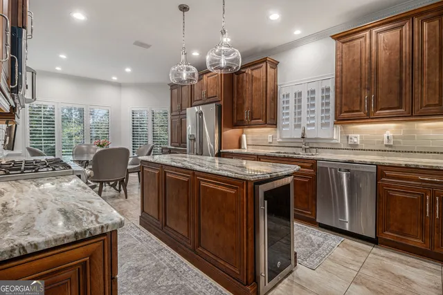 a kitchen with kitchen island granite countertop a stove and a sink