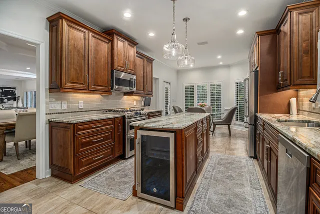 a kitchen with kitchen island granite countertop a stove top oven a sink dishwasher and wooden cabinets