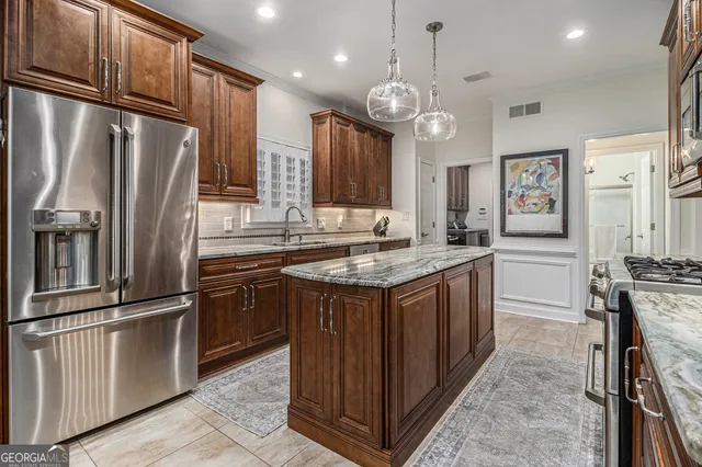 a kitchen with granite countertop stainless steel appliances a stove refrigerator and cabinets