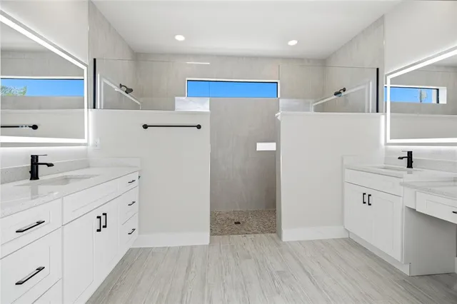 a view of a kitchen with white cabinets and wooden floor