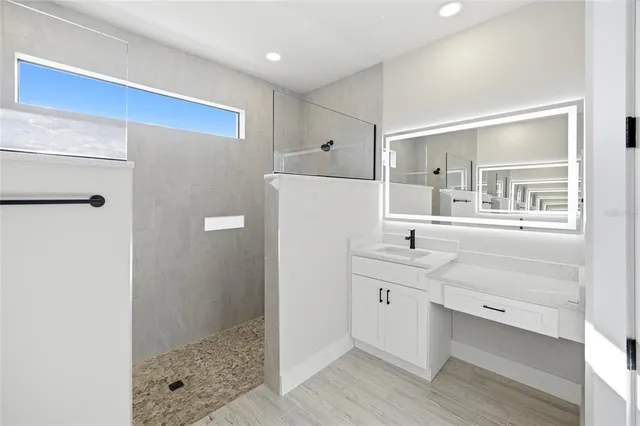 a bathroom with a double vanity sink a mirror and a shower