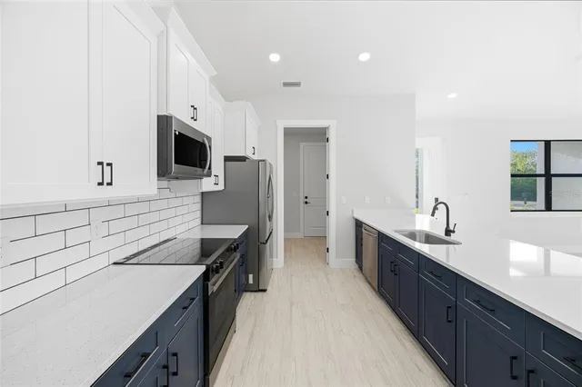 a large kitchen with kitchen island a sink stainless steel appliances and cabinets