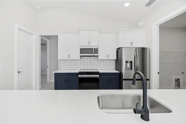 a kitchen with a refrigerator and a stove top oven