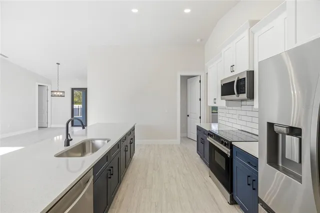 a kitchen with stainless steel appliances a sink stove and refrigerator