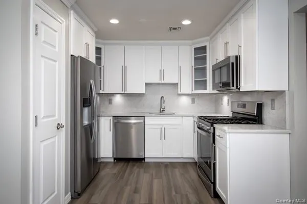 a kitchen with stainless steel appliances granite countertop a stove a refrigerator and a microwave