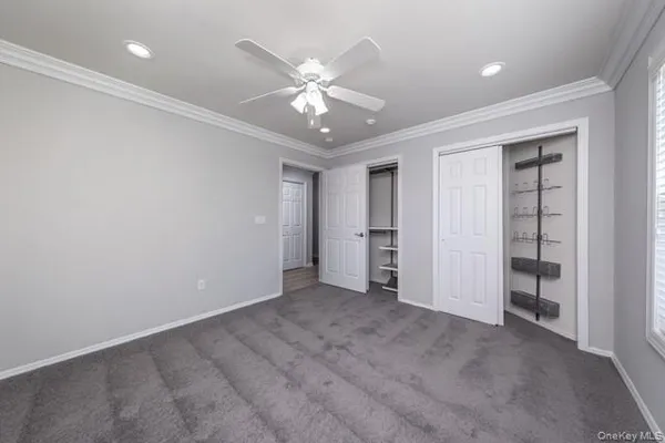 an empty room with closet and fan
