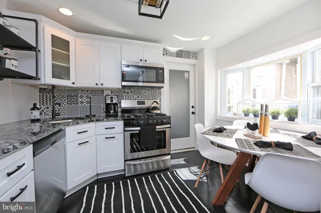a kitchen with stainless steel appliances kitchen island granite countertop a stove and a sink