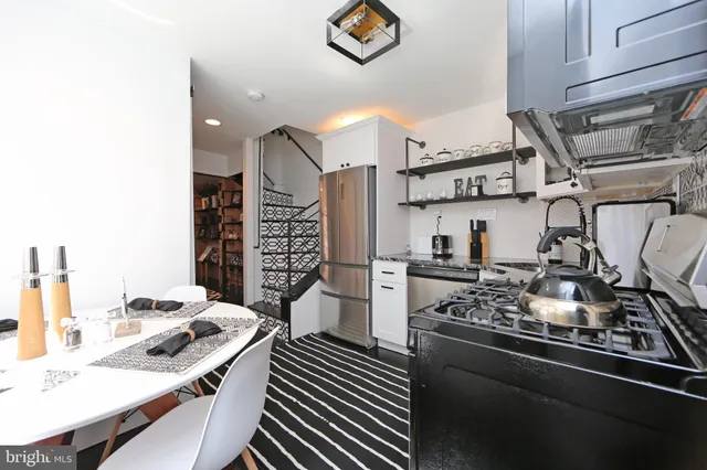 a kitchen with stainless steel appliances kitchen island granite countertop a sink stove and refrigerator
