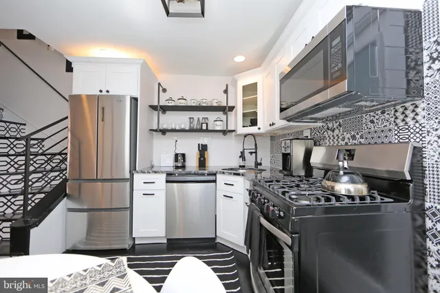 a kitchen with stainless steel appliances a refrigerator stove microwave and sink
