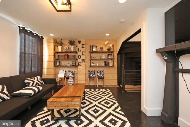 a hallway with a view of living room with furniture and a rug